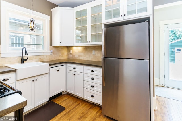 4709 Colfax Ave S, Minneapolis, MN 55419 - kitchen featuring freestanding refrigerator, wood-type flooring, white cabinetry, pendant lighting, and tasteful backsplash