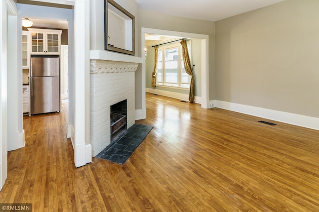 4709 Colfax Ave S, Minneapolis, MN 55419 - unfurnished living room featuring a brick fireplace and wood finished floors
