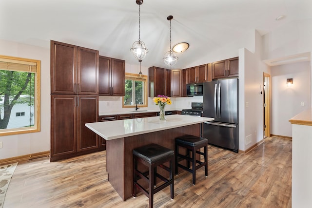 818 Myrtle St, Buffalo, MN 55313 - kitchen with black appliances, light countertops, a breakfast bar, a center island, and healthy amount of natural light