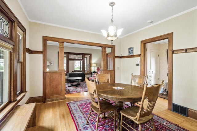 5043 Nokomis Ave, Minneapolis, MN 55417 - dining space featuring light wood finished floors, ornamental molding, a chandelier, and ornate columns
