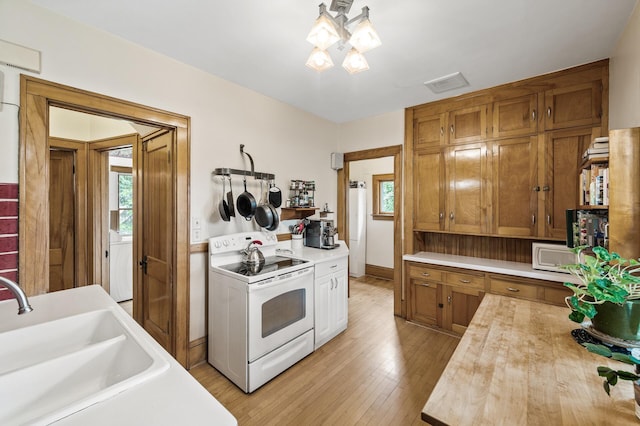5043 Nokomis Ave, Minneapolis, MN 55417 - kitchen with white appliances, plenty of natural light, light wood-type flooring, and brown cabinetry