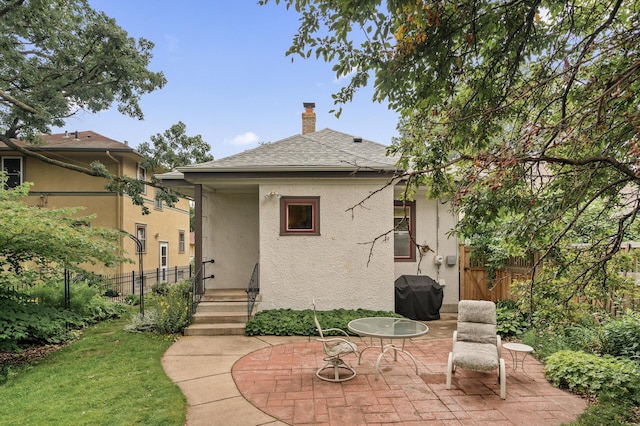 5043 Nokomis Ave, Minneapolis, MN 55417 - rear view of house featuring stucco siding, a chimney, a patio area, and roof with shingles