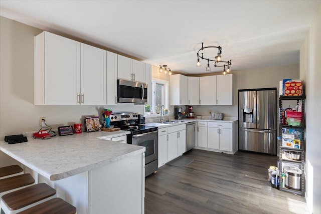 4069 Dublin Rd, Hibbing, MN 55746 - kitchen featuring appliances with stainless steel finishes, a peninsula, light countertops, and white cabinets