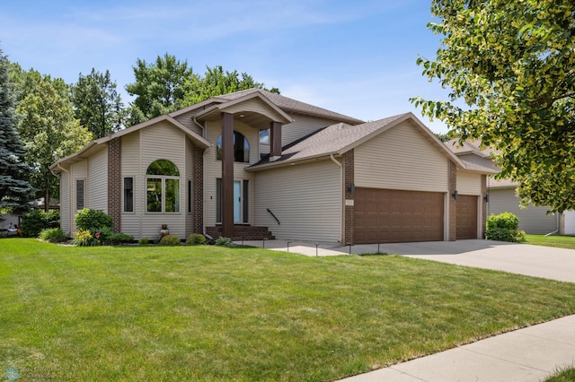 525 20 1/2 Ave E, West Fargo, ND 58078 - view of front of house featuring a garage, concrete driveway, a front yard, a shingled roof, and brick siding