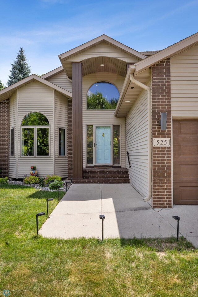 525 20 1/2 Ave E, West Fargo, ND 58078 - doorway to property with a yard and brick siding