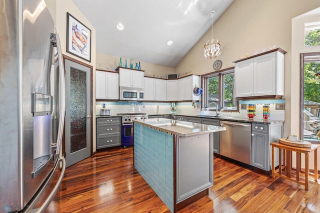 525 20 1/2 Ave E, West Fargo, ND 58078 - kitchen with stainless steel appliances, high vaulted ceiling, dark wood finished floors, decorative backsplash, and plenty of natural light