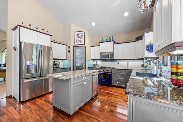 525 20 1/2 Ave E, West Fargo, ND 58078 - kitchen featuring appliances with stainless steel finishes, dark stone counters, a kitchen island, backsplash, and high vaulted ceiling