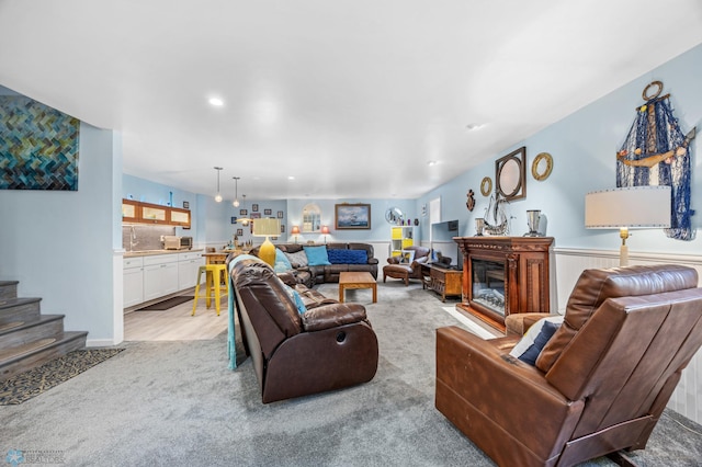 525 20 1/2 Ave E, West Fargo, ND 58078 - living room featuring light carpet, a glass covered fireplace, recessed lighting, and stairs