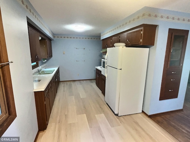 1938 149th Ave NE, Ham Lake, MN 55304 - kitchen featuring freestanding refrigerator, dark brown cabinets, light wood-style flooring, and light countertops