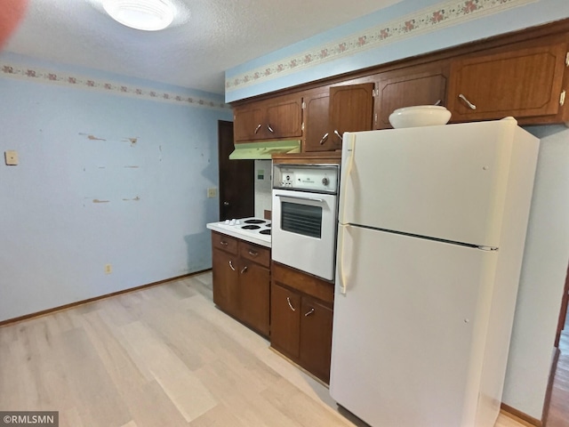 1938 149th Ave NE, Ham Lake, MN 55304 - kitchen with white appliances, under cabinet range hood, a textured ceiling, light wood-style flooring, and light countertops