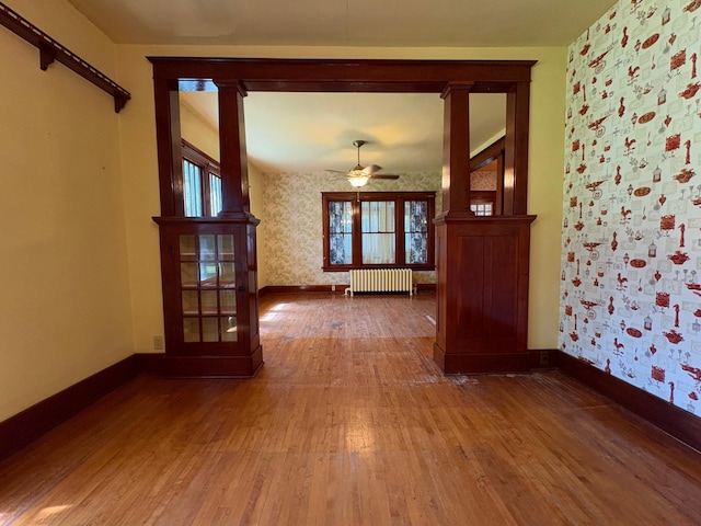 201 3rd St SE, Renville, MN 56284 - spare room with radiator heating unit, wallpapered walls, hardwood / wood-style flooring, and ceiling fan