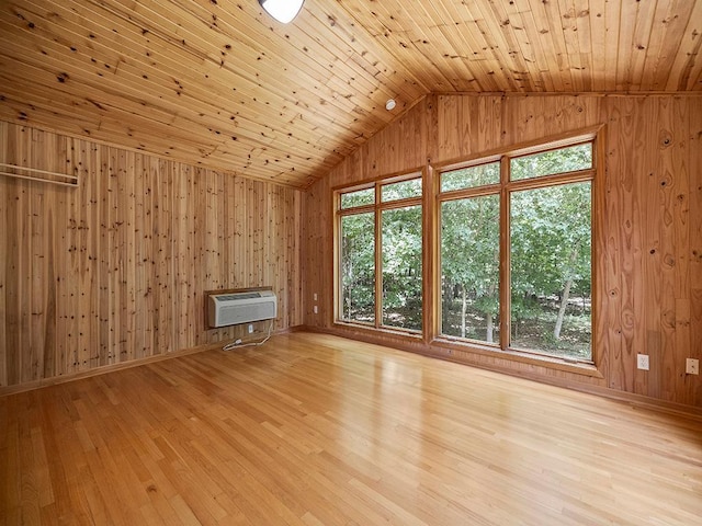 20980 Parkfield Ave, Spring Lake Twp, MN 55352 - unfurnished living room featuring wooden walls, vaulted ceiling, plenty of natural light, a wall mounted AC, and light wood-style floors