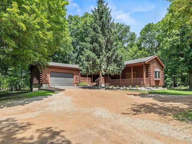 20980 Parkfield Ave, Spring Lake Twp, MN 55352 - cabin featuring log exterior, covered porch, driveway, and a garage