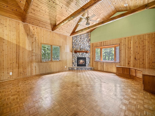 20980 Parkfield Ave, Spring Lake Twp, MN 55352 - unfurnished living room with high vaulted ceiling, wooden walls, a wood ceiling with exposed beams, a ceiling fan, and a stone fireplace