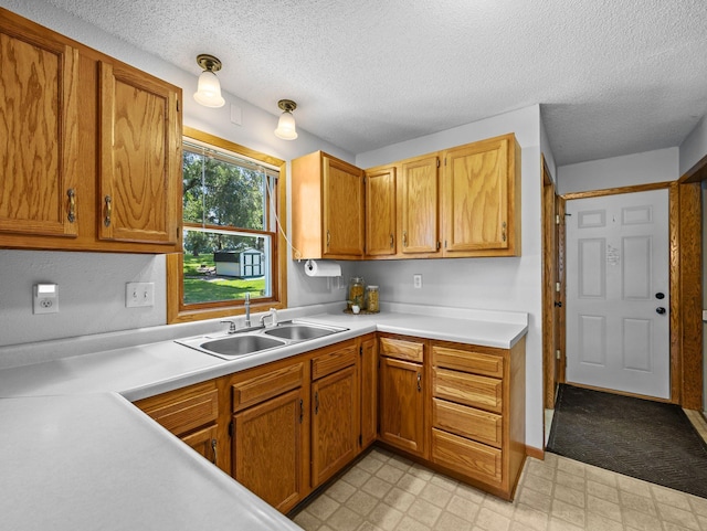 724 2nd Ave S, Buffalo, MN 55313 - kitchen featuring light flooring, light countertops, a textured ceiling, and brown cabinets