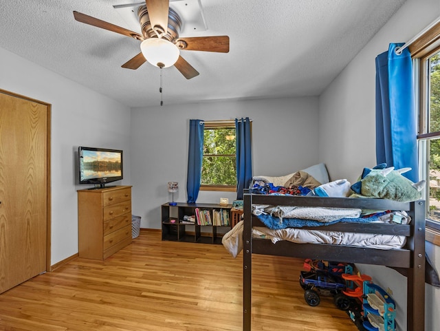 724 2nd Ave S, Buffalo, MN 55313 - bedroom featuring light wood-style flooring, a textured ceiling, multiple windows, and ceiling fan