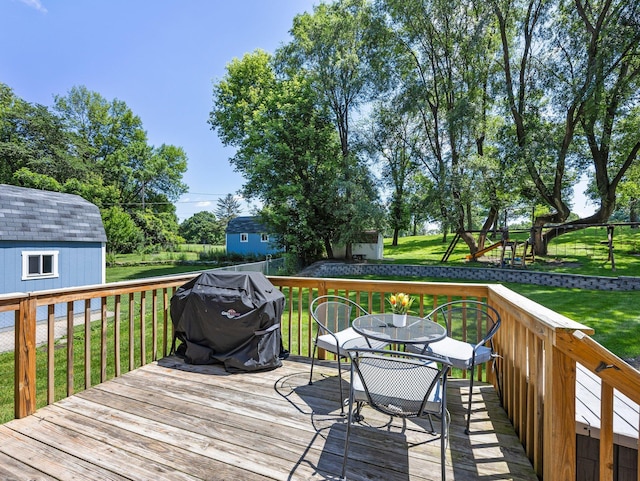 724 2nd Ave S, Buffalo, MN 55313 - wooden terrace with grilling area, outdoor dining area, a lawn, and a playground