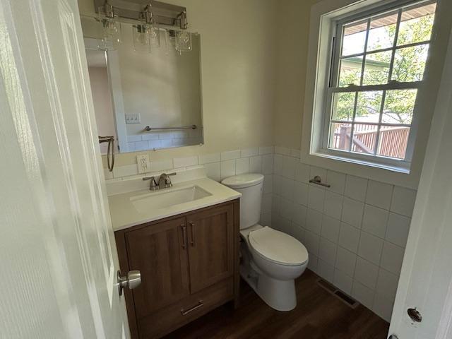 504 8th Ave, Grand Rapids, MN 55744 - bathroom featuring tile walls, vanity, wood finished floors, and a wainscoted wall