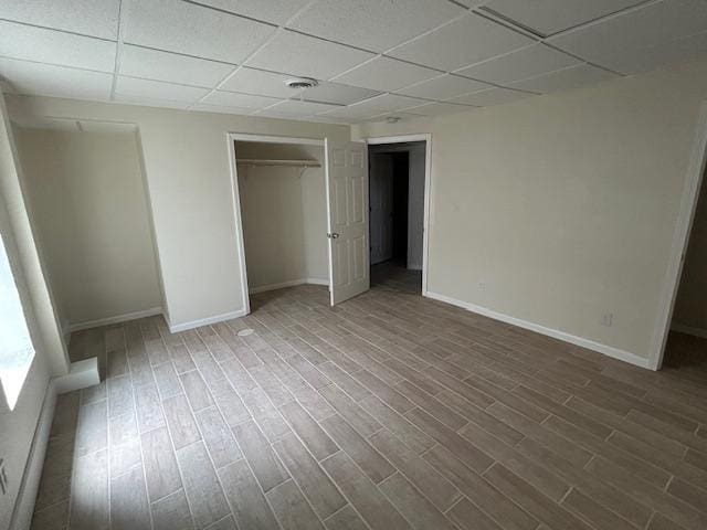 504 8th Ave, Grand Rapids, MN 55744 - unfurnished bedroom featuring a drop ceiling, wood finished floors, and a closet