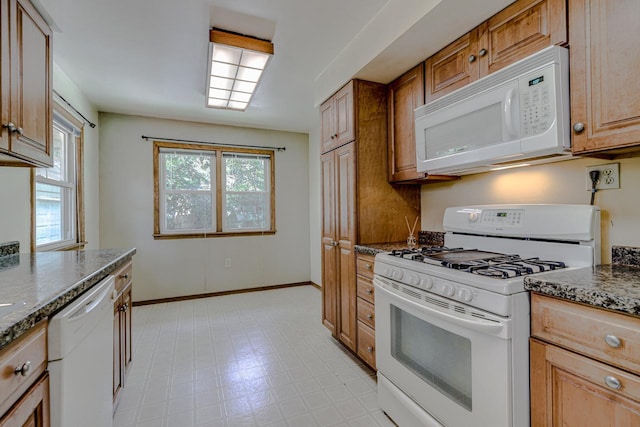 1970 Maryknoll Ave, Maplewood, MN 55109 - kitchen with white appliances, dark stone counters, light floors, and brown cabinetry