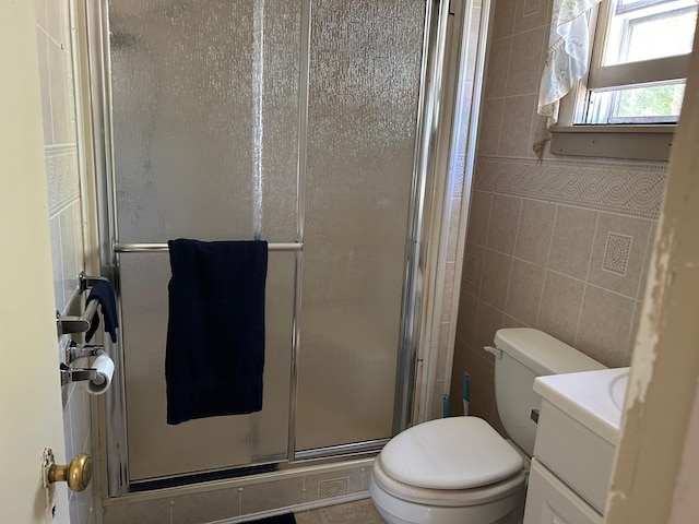 823 5th St, Grand Rapids, MN 55744 - bathroom with vanity, a shower stall, and tile walls