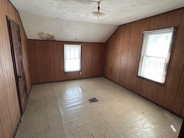 823 5th St, Grand Rapids, MN 55744 - bonus room featuring lofted ceiling, wooden walls, and a textured ceiling
