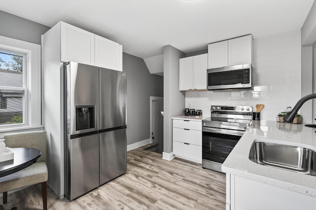 4301 Columbus Ave, Minneapolis, MN 55407 - kitchen with stainless steel appliances, white cabinets, and light wood finished floors