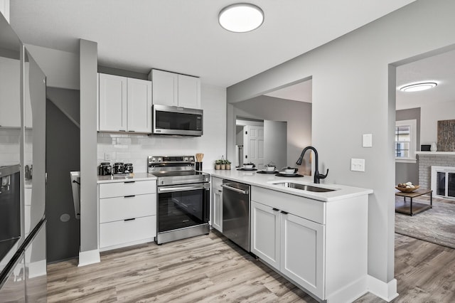 4301 Columbus Ave, Minneapolis, MN 55407 - kitchen with stainless steel appliances, light wood-style flooring, light countertops, and white cabinetry