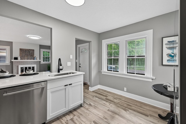 4301 Columbus Ave, Minneapolis, MN 55407 - kitchen with dishwasher, white cabinetry, light wood finished floors, and light countertops