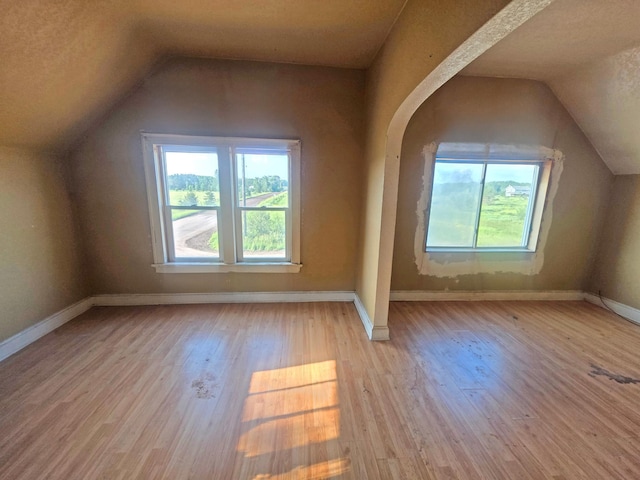 2001 Shilhon Rd, Duluth, MN 55804 - additional living space featuring vaulted ceiling, healthy amount of natural light, wood finished floors, and arched walkways