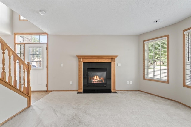 5607 100th Ln N, Brooklyn Park, MN 55443 - unfurnished living room with carpet, stairs, a textured ceiling, and a fireplace with flush hearth