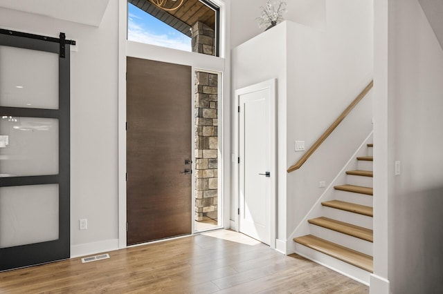 16830 59th Ave N, Plymouth, MN 55446 - entrance foyer with wood finished floors, a barn door, stairs, and a towering ceiling