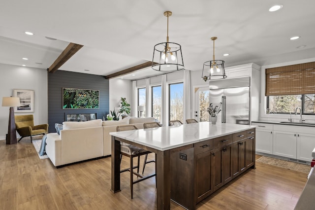 16830 59th Ave N, Plymouth, MN 55446 - kitchen featuring stainless steel built in refrigerator, a kitchen bar, recessed lighting, light wood finished floors, and white cabinets