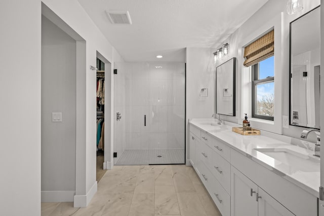 16830 59th Ave N, Plymouth, MN 55446 - full bathroom featuring marble finish floors, double vanity, a shower stall, and a walk in closet