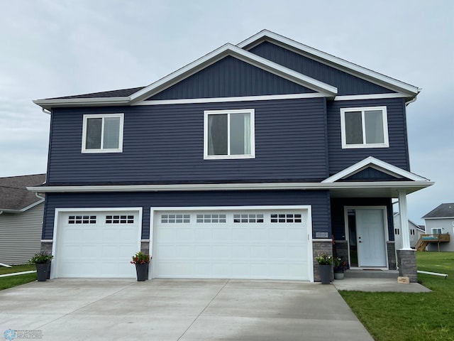 1819 67th Ave S, Fargo, ND 58104 - view of front facade featuring a garage, concrete driveway, and stone siding