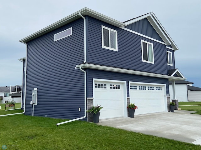 1819 67th Ave S, Fargo, ND 58104 - view of property exterior featuring a garage, a yard, driveway, and stone siding