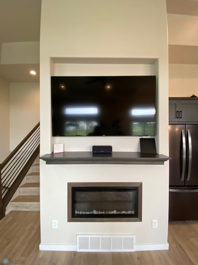 1819 67th Ave S, Fargo, ND 58104 - detailed view of freestanding refrigerator, wood finished floors, and a glass covered fireplace