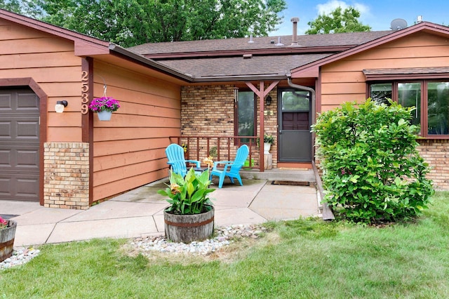 2539 83rd Ct N, Brooklyn Park, MN 55444 - view of exterior entry with brick siding, a garage, roof with shingles, and a lawn