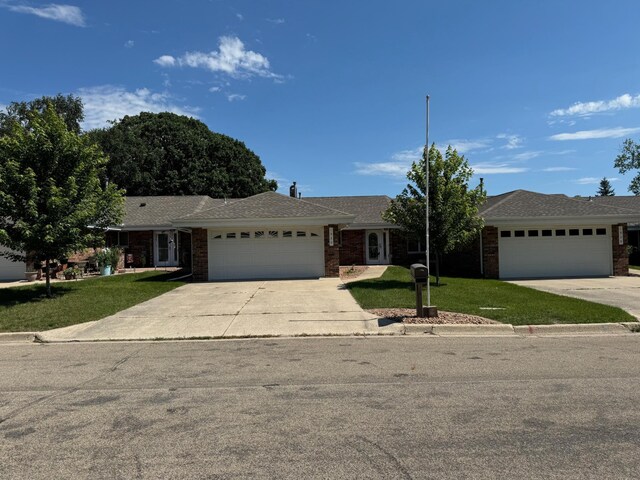 1930 Wilby Rd, Albert Lea, MN 56007 - ranch-style house featuring an attached garage, driveway, a front yard, and brick siding