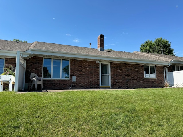 1930 Wilby Rd, Albert Lea, MN 56007 - back of property featuring a chimney, a yard, brick siding, and a shingled roof