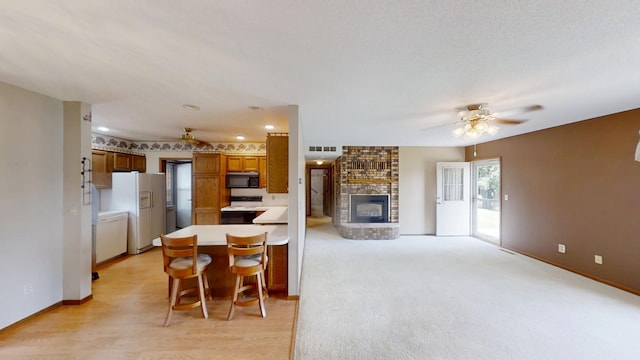1930 Wilby Rd, Albert Lea, MN 56007 - kitchen featuring white appliances, a ceiling fan, brown cabinetry, a peninsula, and recessed lighting