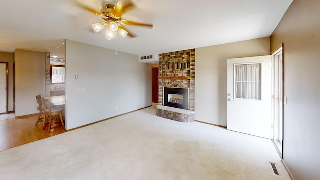 1930 Wilby Rd, Albert Lea, MN 56007 - unfurnished living room with a ceiling fan, carpet floors, and a brick fireplace