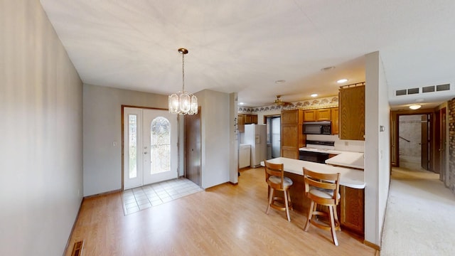 1930 Wilby Rd, Albert Lea, MN 56007 - kitchen featuring white appliances, brown cabinetry, light countertops, a peninsula, and light wood-style floors