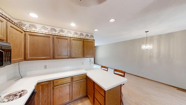 1930 Wilby Rd, Albert Lea, MN 56007 - kitchen featuring a peninsula, black microwave, tasteful backsplash, light wood finished floors, and recessed lighting