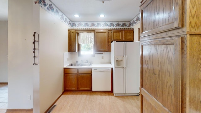 1930 Wilby Rd, Albert Lea, MN 56007 - kitchen featuring white appliances, decorative backsplash, light countertops, light wood finished floors, and brown cabinetry