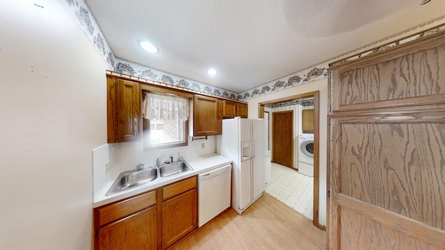 1930 Wilby Rd, Albert Lea, MN 56007 - kitchen with white appliances, washer / dryer, light countertops, light floors, and brown cabinets