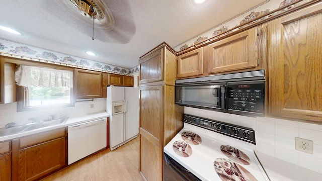 1930 Wilby Rd, Albert Lea, MN 56007 - kitchen with white appliances, light countertops, tasteful backsplash, light wood finished floors, and brown cabinets