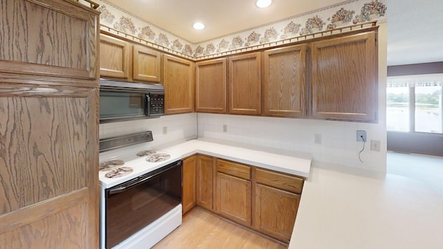 1930 Wilby Rd, Albert Lea, MN 56007 - kitchen with electric range, black microwave, decorative backsplash, light countertops, and brown cabinets