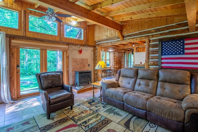 31759 County 30, Laporte, MN 56461 - living room featuring a wood stove, a wooden ceiling with exposed beams, a ceiling fan, wood walls, and tile patterned floors