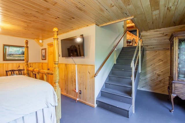 31759 County 30, Laporte, MN 56461 - bedroom featuring wooden walls, wood ceiling, concrete flooring, and a wainscoted wall
